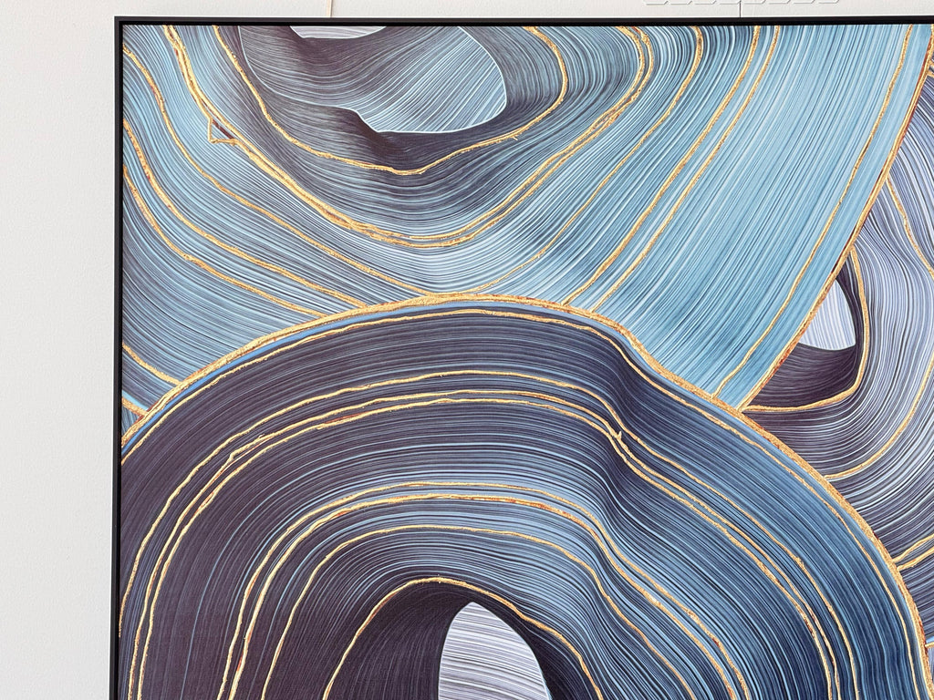 Close-up of ribbon-inspired wall art showcasing green and grey tones with metallic gold accents in a sleek black frame.