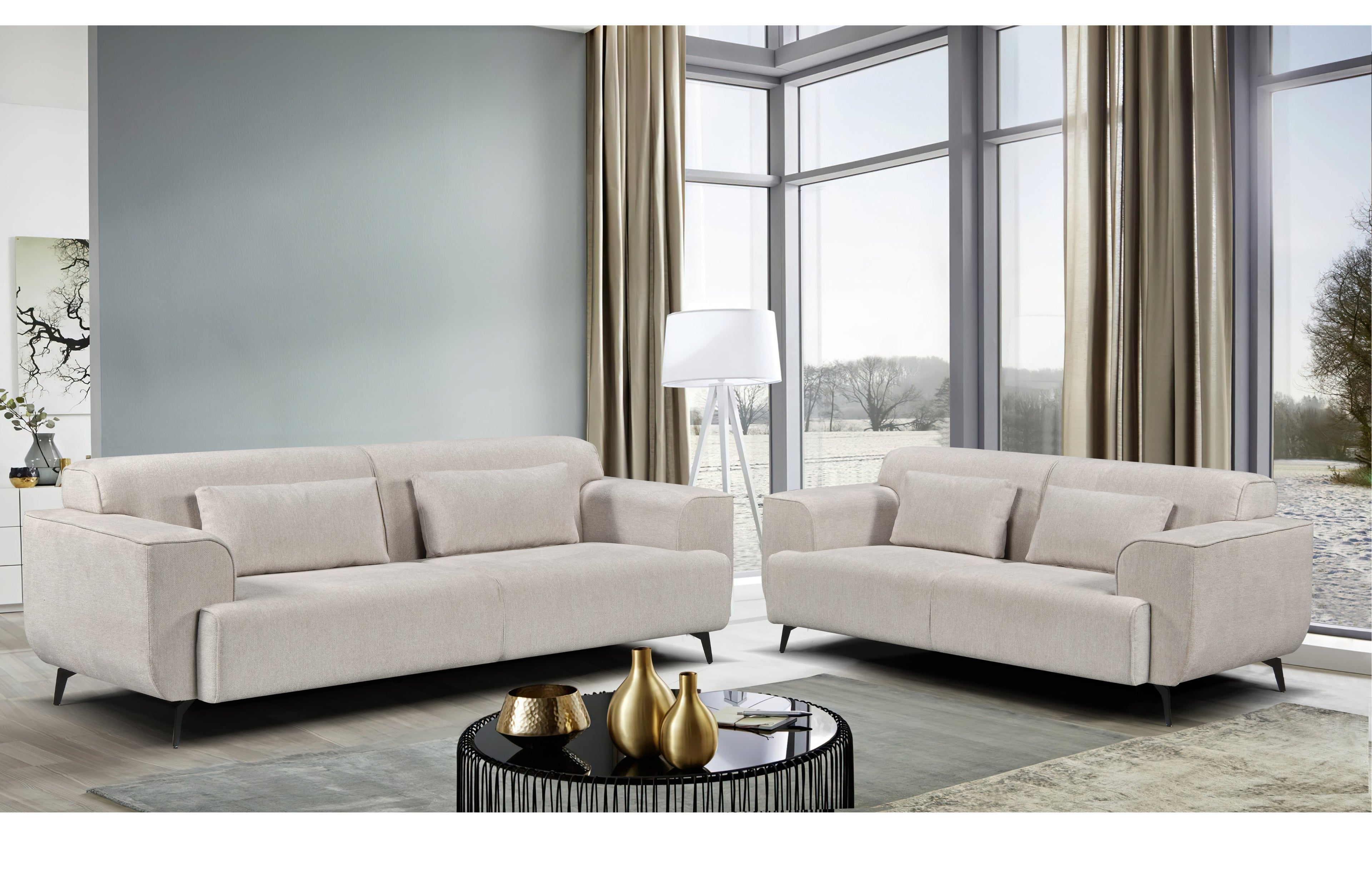 Maddox Lounge Set in beige displayed in a modern living room includes a 3-seater and 2-seater fixed sofa with sleek black metal legs, soft-touch fabric, and matching cushions for a clean, contemporary aesthetic.
