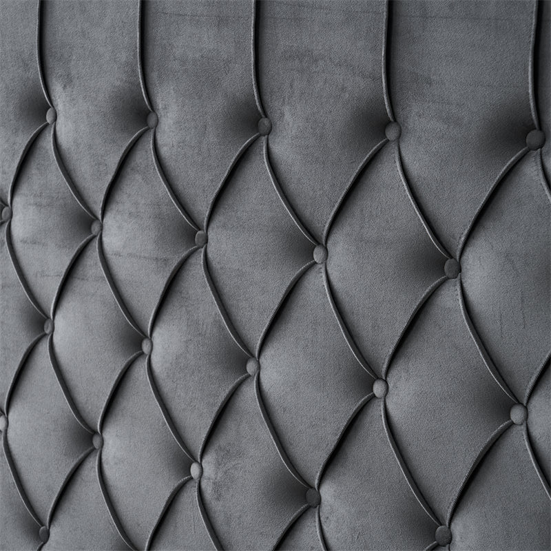 Dark grey tufted velvet headboard close-up.