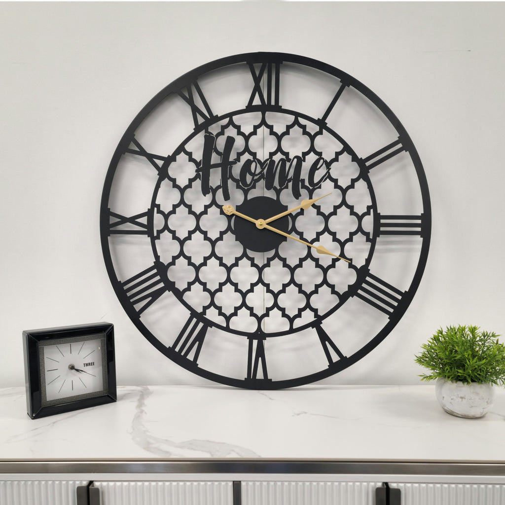 Black quatrefoil wall clock styled above console table, contemporary and elegant decorative timepiece.