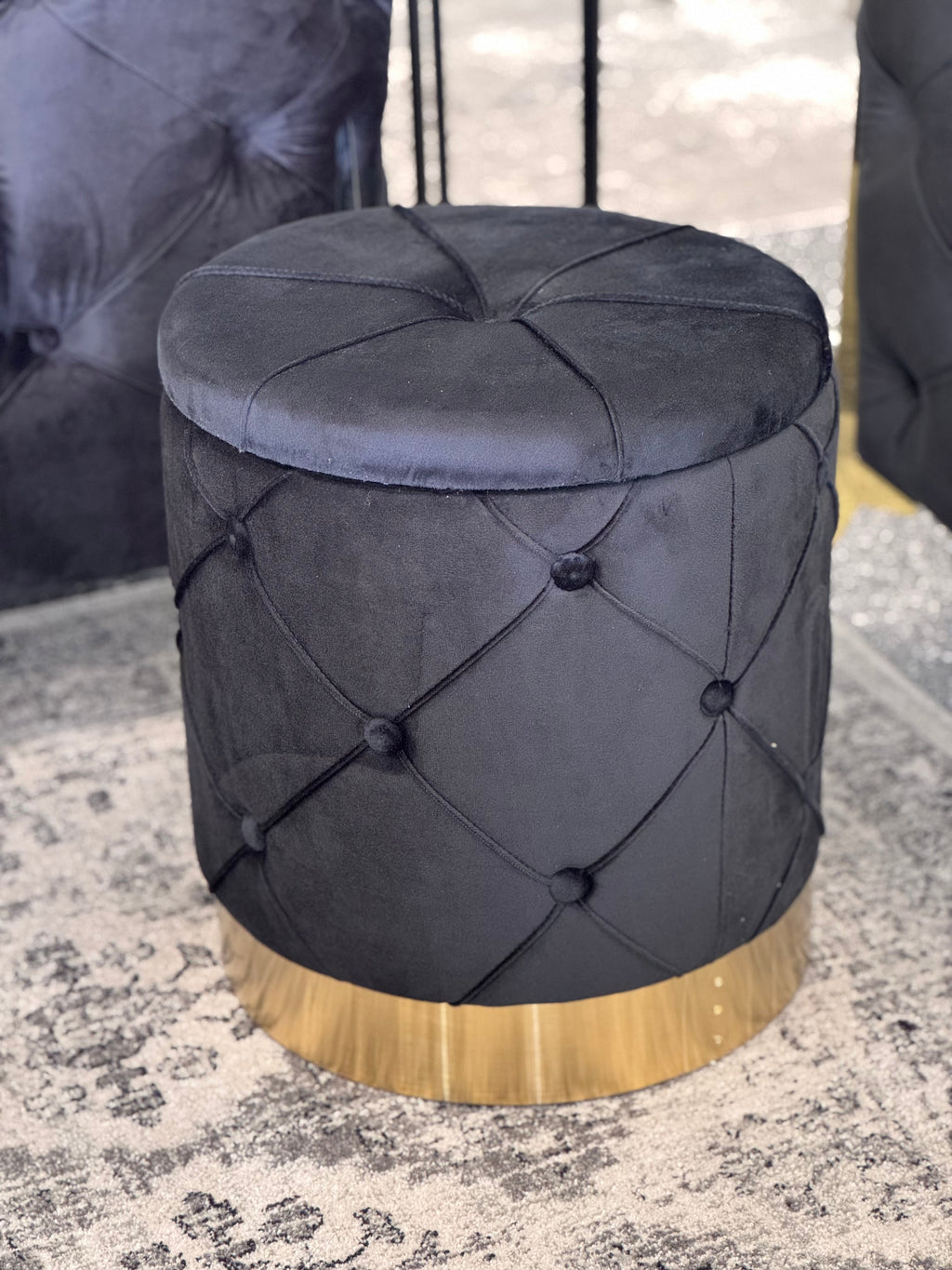 Black Amy Storage Ottoman with gold base styled in room setting with modern décor