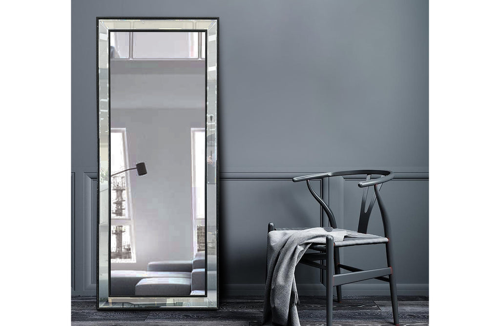 Medium black beaded framed mirror styled against dark grey wall with chair.