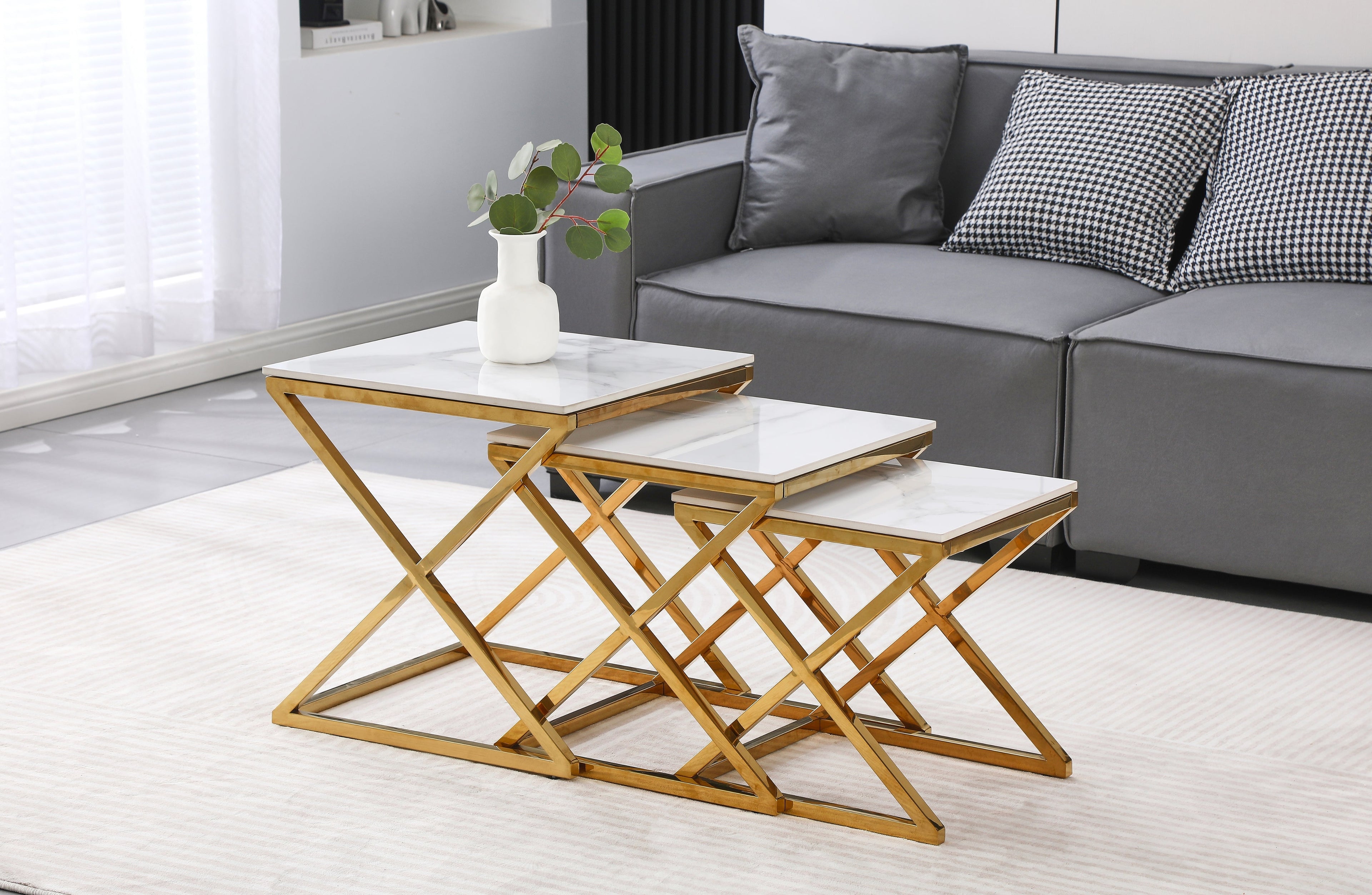 Bella side table set with polished gold frame and marble stone tops, styled in modern lounge.