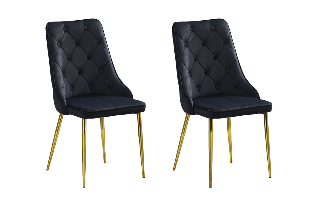 Set of 2 black velvet button tufted dining chairs with gold legs in studio setting.