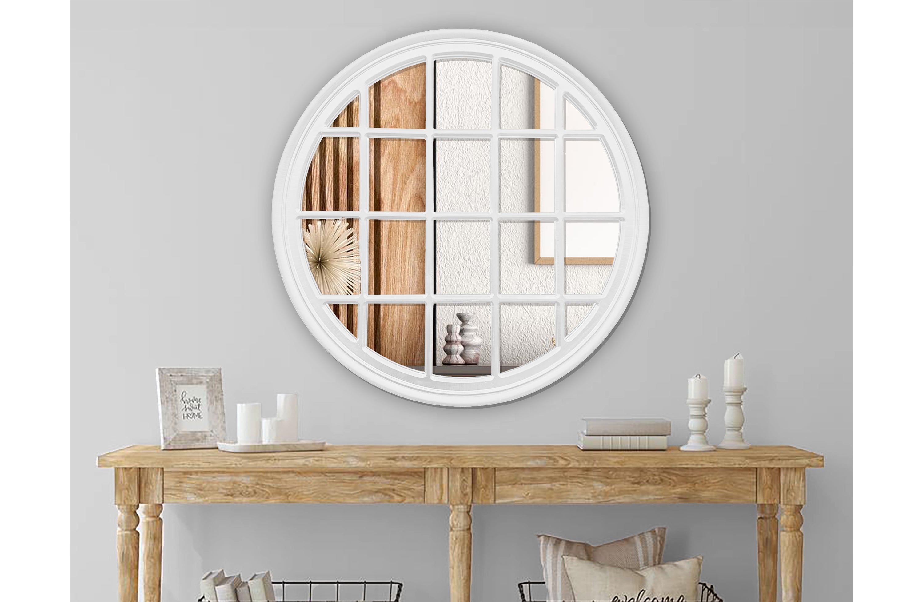 White Hampton's round window mirror styled above wooden console in elegant hallway.