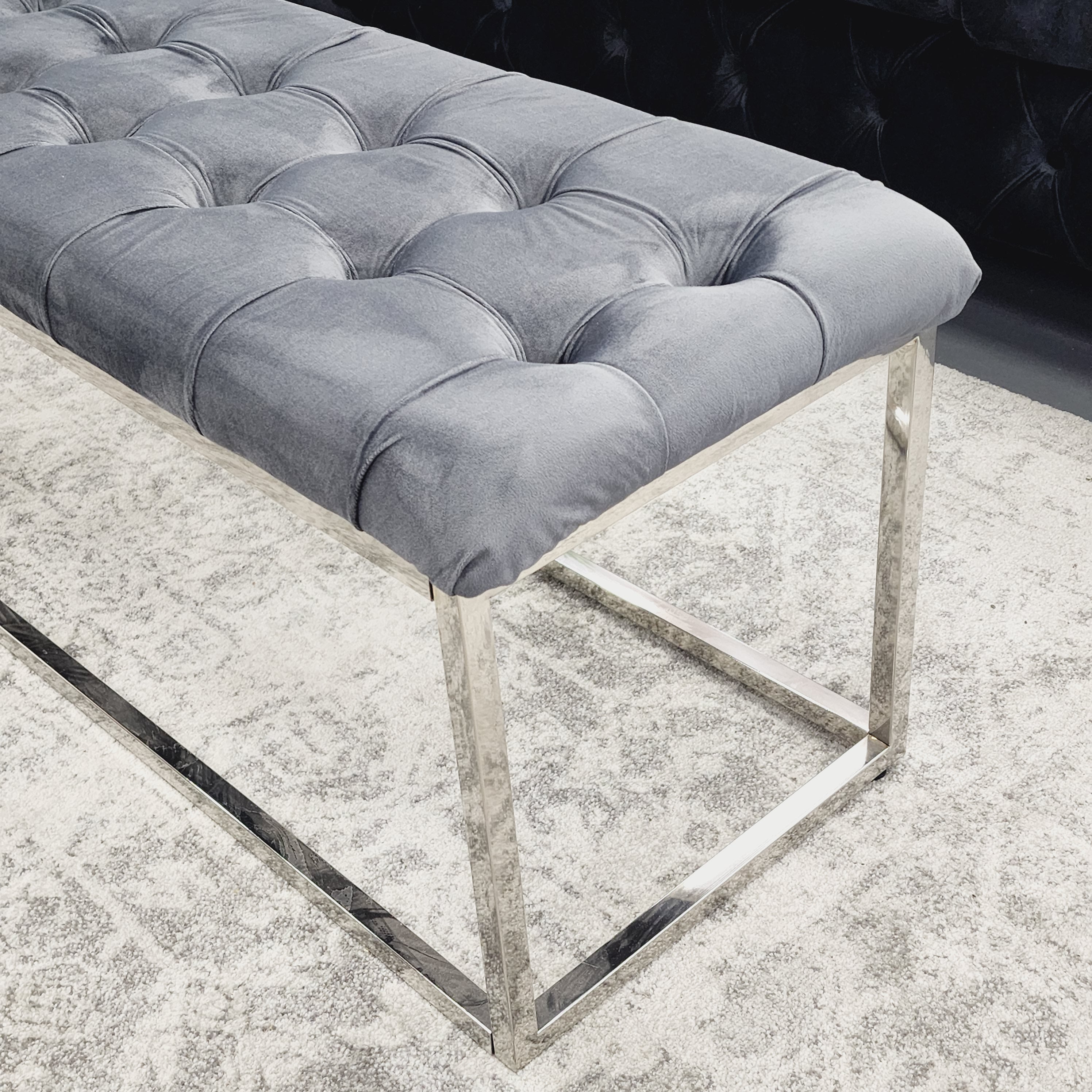 Close-up of Grey Holly Ottoman Bench with silver polished frame and tufted velvet seat.