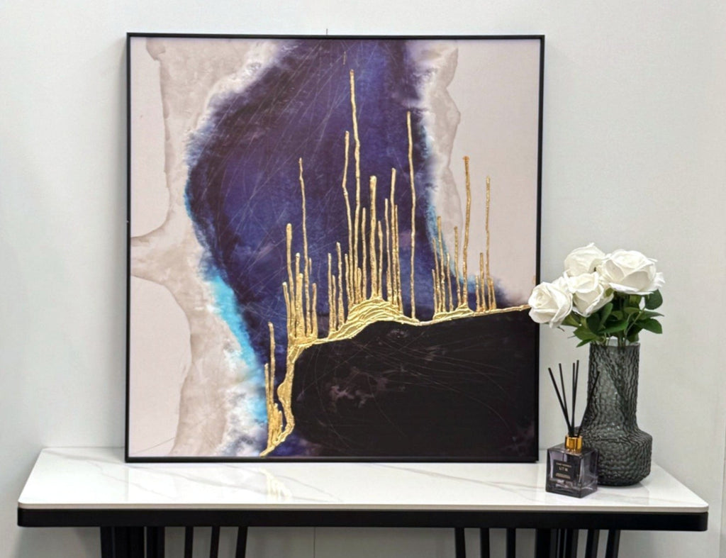 Elegant blue and black wall art with gold foil, styled above a console table.