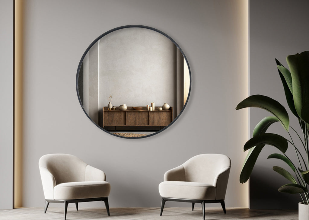 Black round wall mirror styled above modern lounge with two armchairs