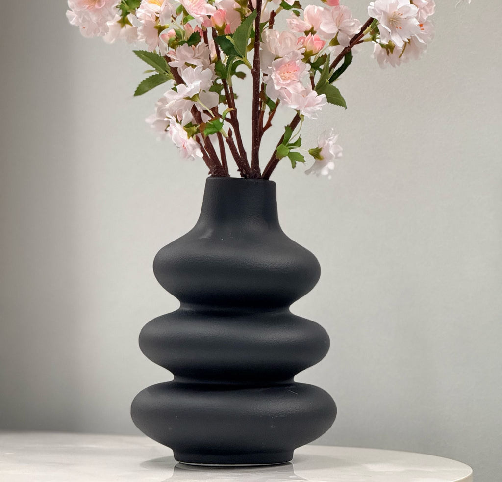 Black Nordic bubble vase with soft pink flowers, adding elegance to any setting.