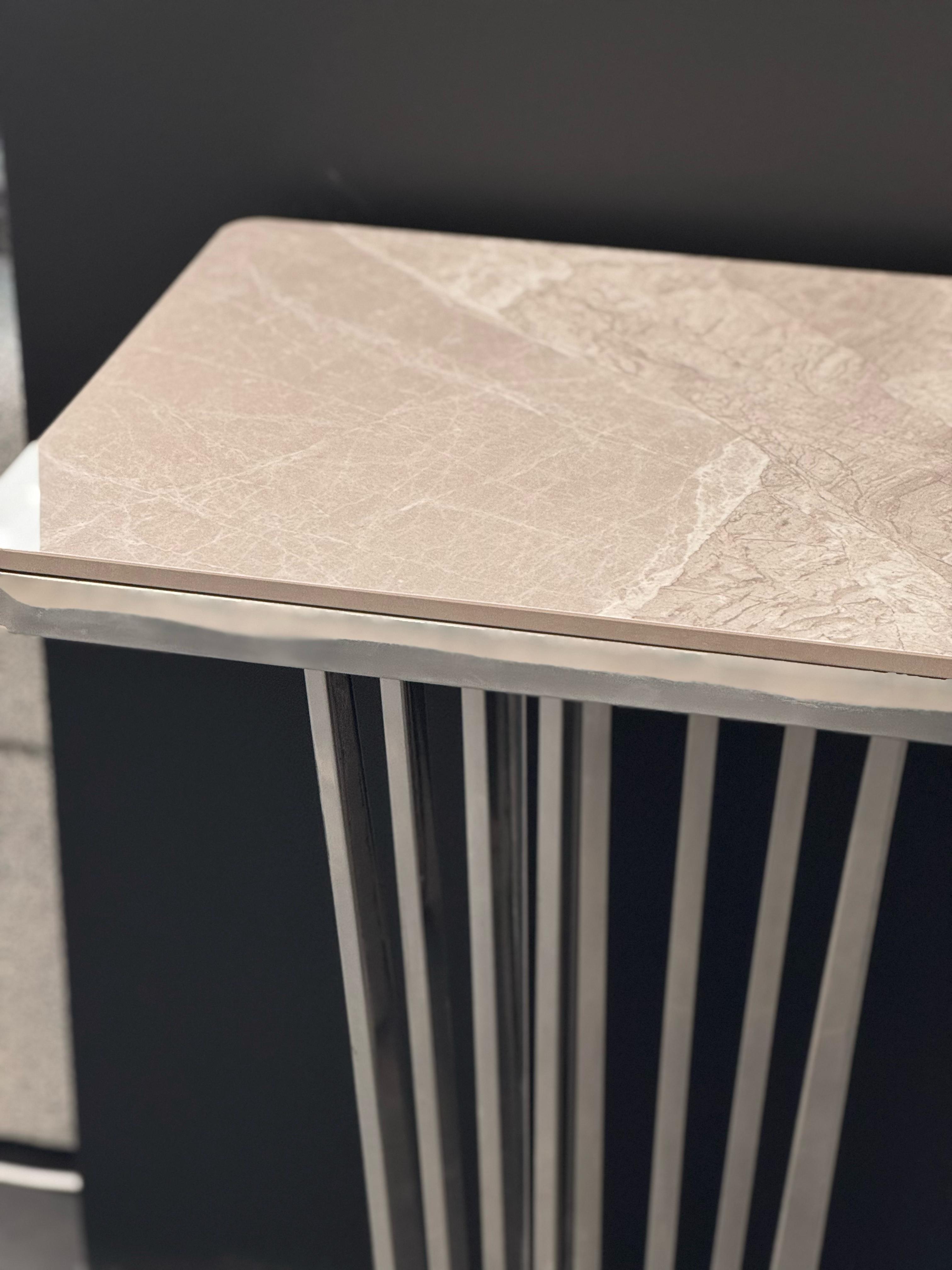 Close-up of Serena console table with polished silver frame and grey marble top.