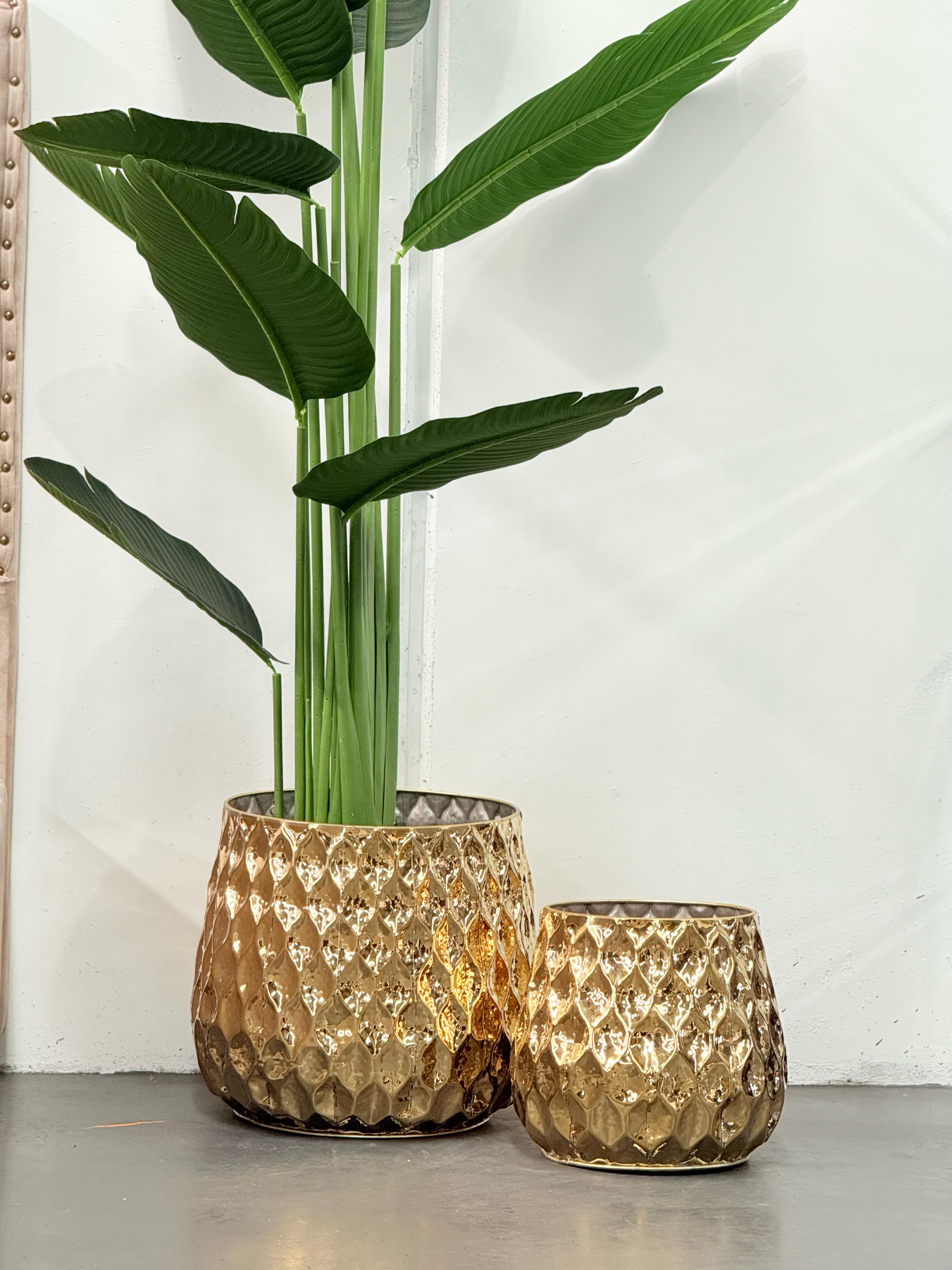 Teagon Planter set in shiny gold with tall plant in styled room setting.