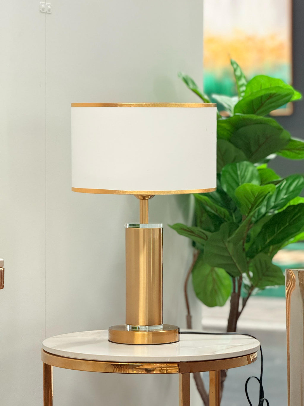 Tiffany Table Lamp with gold base and white lampshade styled on side table with décor accents