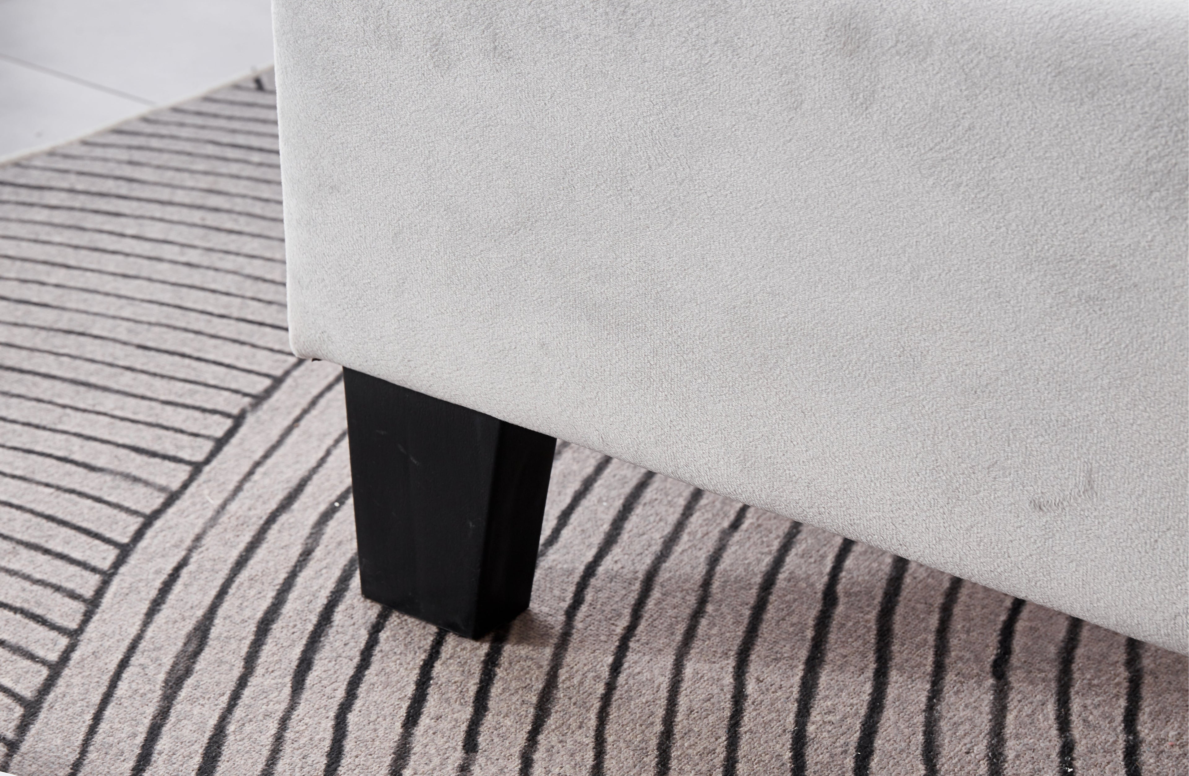 Close-up of Winston Velvet Bed sturdy black legs with premium light grey velvet base